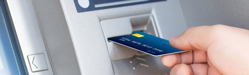 La main de l'homme met la carte de crédit dans l'ATM.